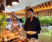 Two individuals joyfully ride a vibrant yellow and black jet ski amidst the picturesque Maldives Resort.